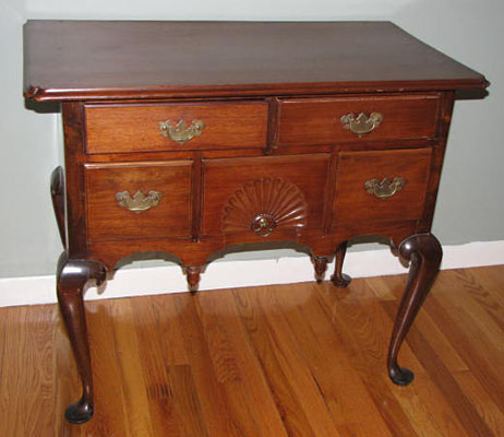 18th century Queen Anne Lowboy with fan carving, acorn drops, and dovetailed case with pad feet in old finish.